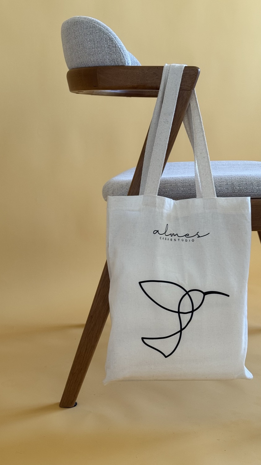 Ecobag de algodão cru Casa Almes com a assinatura e o beija-flor em traço contínuo